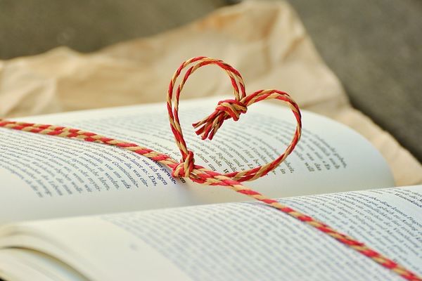 Lieblingsbuch Aufgeschlagenes Buch mit einer Kordel, die ein Herz über den Seiten bildet.