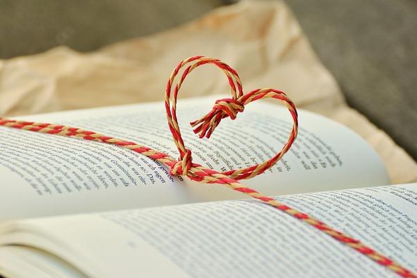 Lieblingsbuch Aufgeschlagenes Buch mit einer Kordel, die ein Herz über den Seiten bildet.