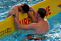 Ein Rettungsschwimmer in Ausbildung: Eine Person wird auf ein Rettungsbrett gerettet.