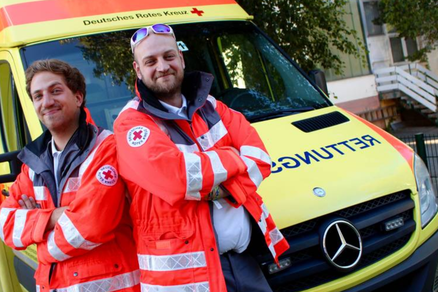 Zwei Helfer unseres Rettungsdienstes vor unserem Rettungswagen