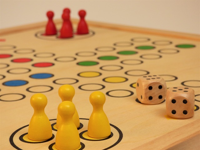 Brettspiel Ein Brettspiel mit roten und gelben Figuren. Zwei Würfel liegen ebenfalls auf dem Spielbrett.